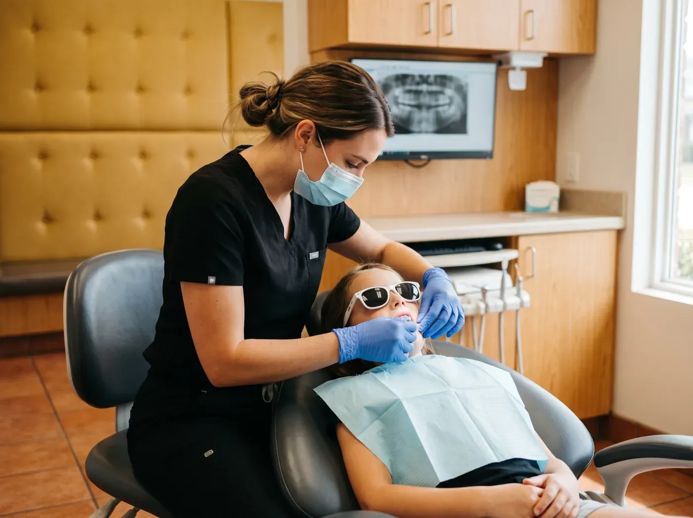A hygienist working with a young patient